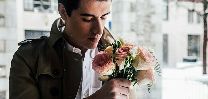 a man smelling a bouquet of roses