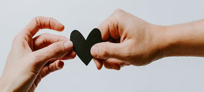 long distance relationship hands holding a heart together